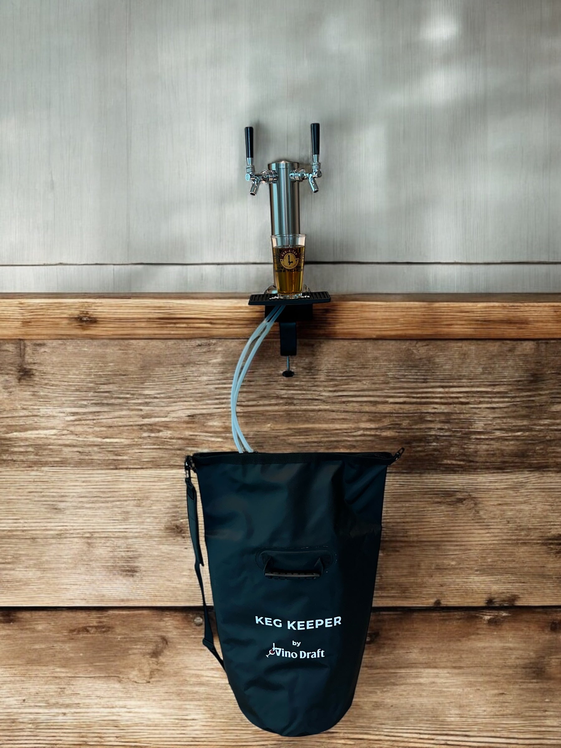 Double faucet clamp-on draft tower with Keg Keeper insulated keg bag cooler and draft beer showing on wooden bar; by Add-A-Tap